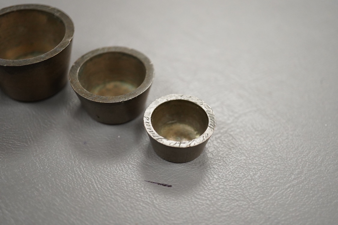 Two sets of bronze Troy nesting weights, one incomplete, with engraved rims, largest 8oz